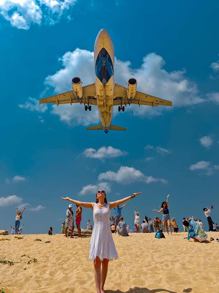 Туристы фотографируются с самолетом на пляже Май Кхао